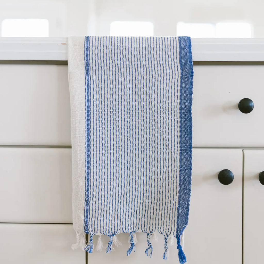 Blue and white striped towel hanging on a white cabinet with black knobs.