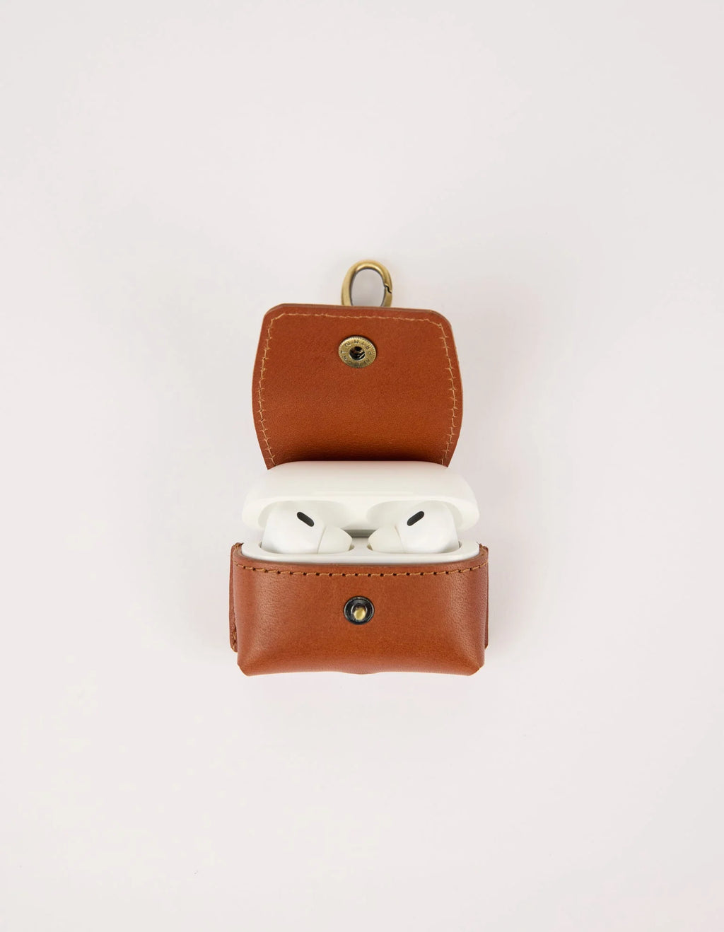 Brown leather case with white wireless earbuds on a light gray background