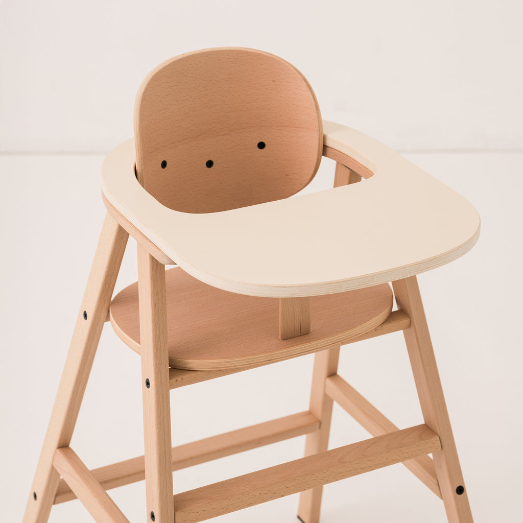 A close up of wooden high chair with tray