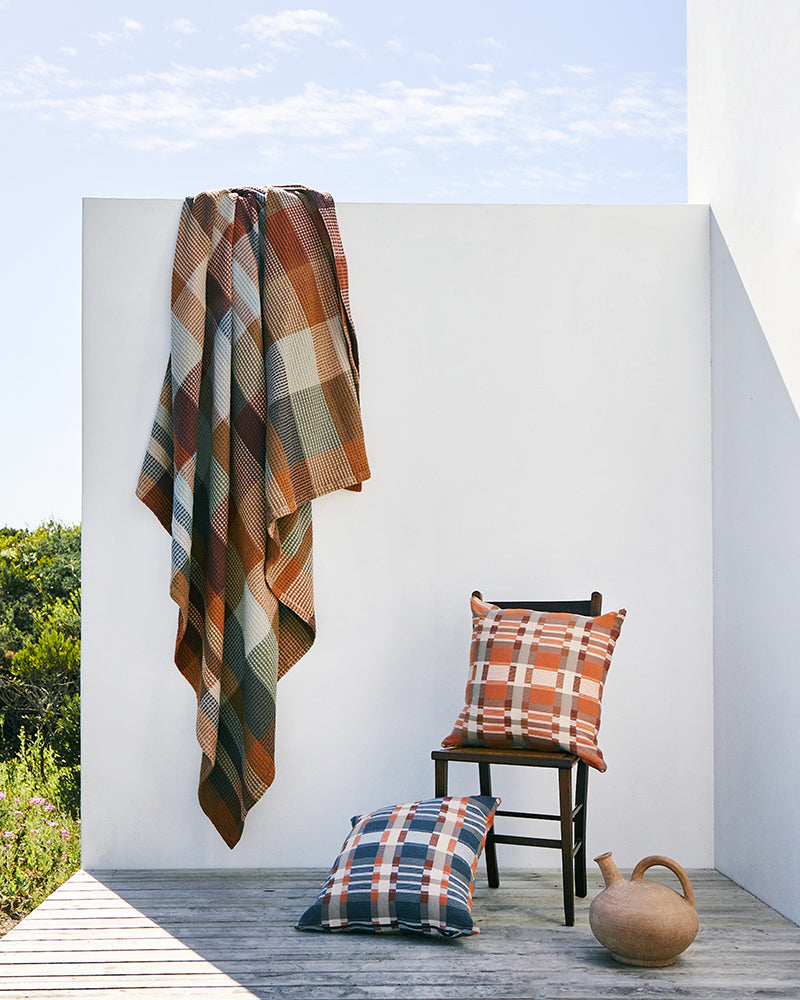 A Vrou blanket draped over wall.