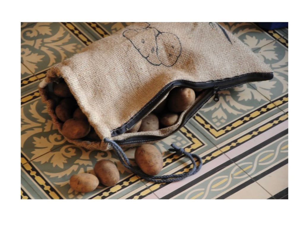 Brown drawstring bag filled with potatoes on a decorative tiled floor