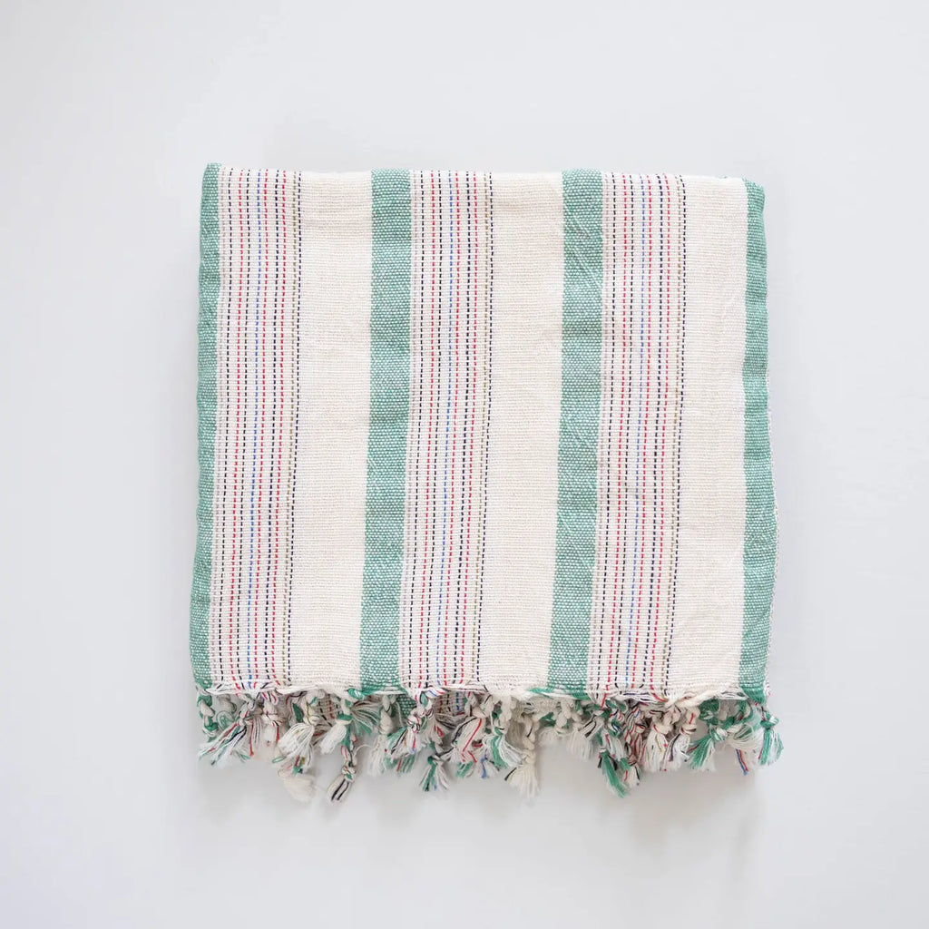Striped towel with fringes on a light gray background