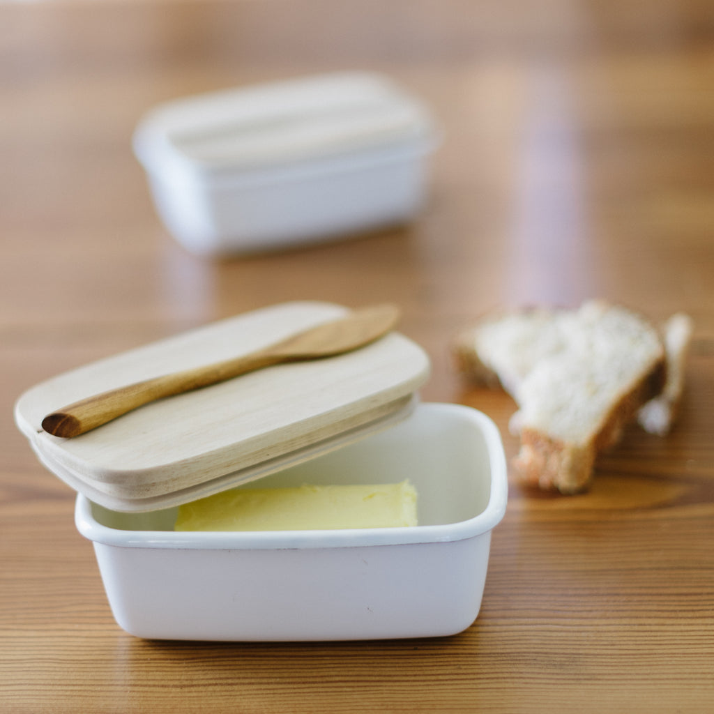 Enamel Storage Container with Acacia Wood Lid with a stick of butter inside of it.