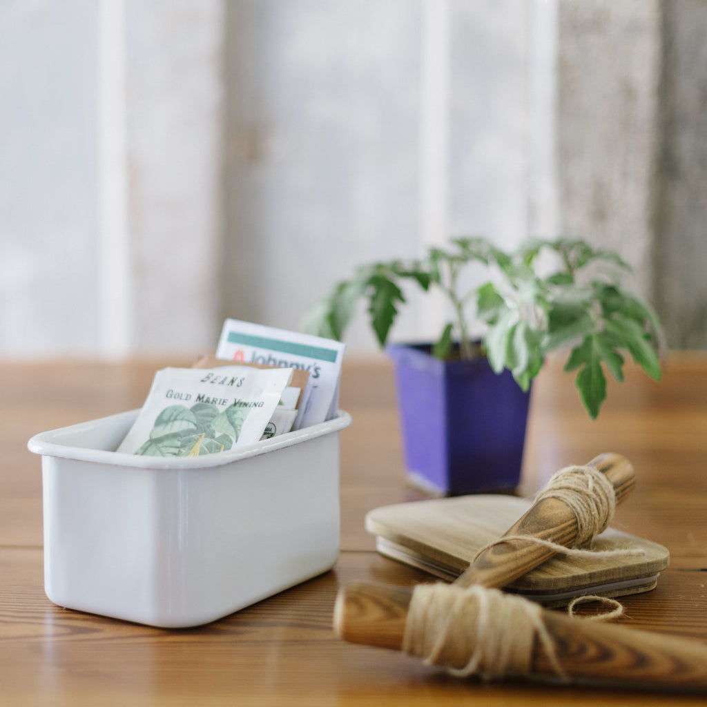 enamel storage container with acacia wood lid with tea bags in it