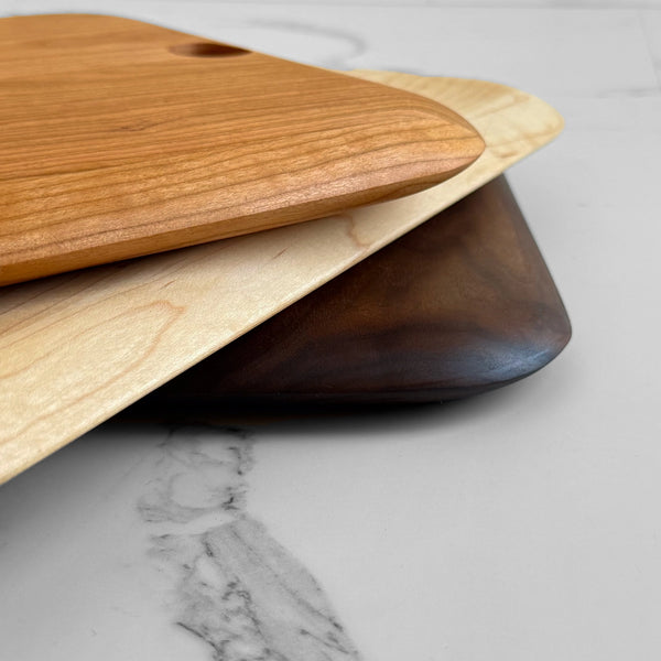 Three wooden cutting boards on a marble surface