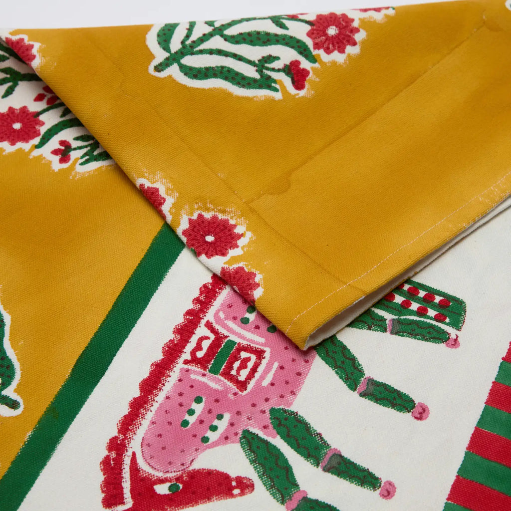 Close-up of a colorful fabric with floral and cactus patterns on a yellow background.