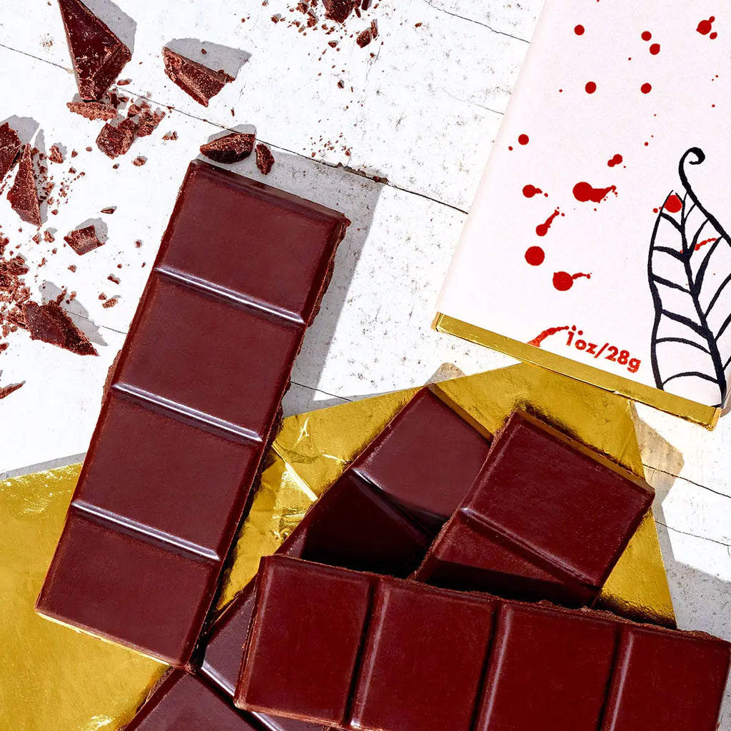 Dark chocolate bars with a gold foil wrapper on a white surface.