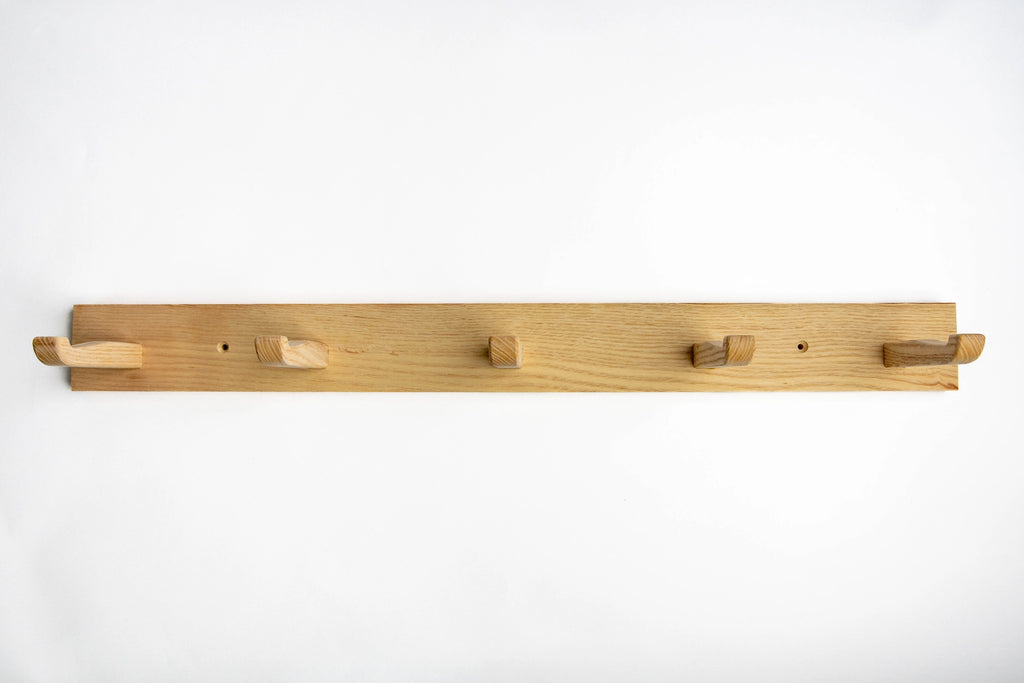 Wooden coat rack with five hooks on a white background