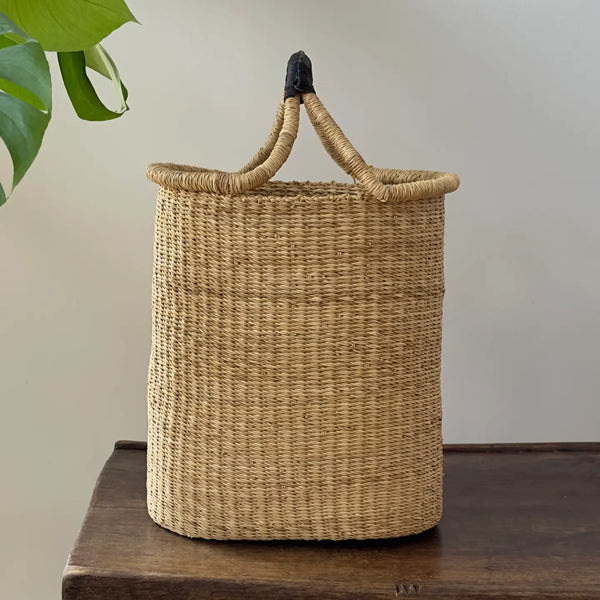 Woven basket with handles on a wooden surface
