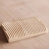 Rectangular ceramics soap dish with grooved surface on a wooden surface