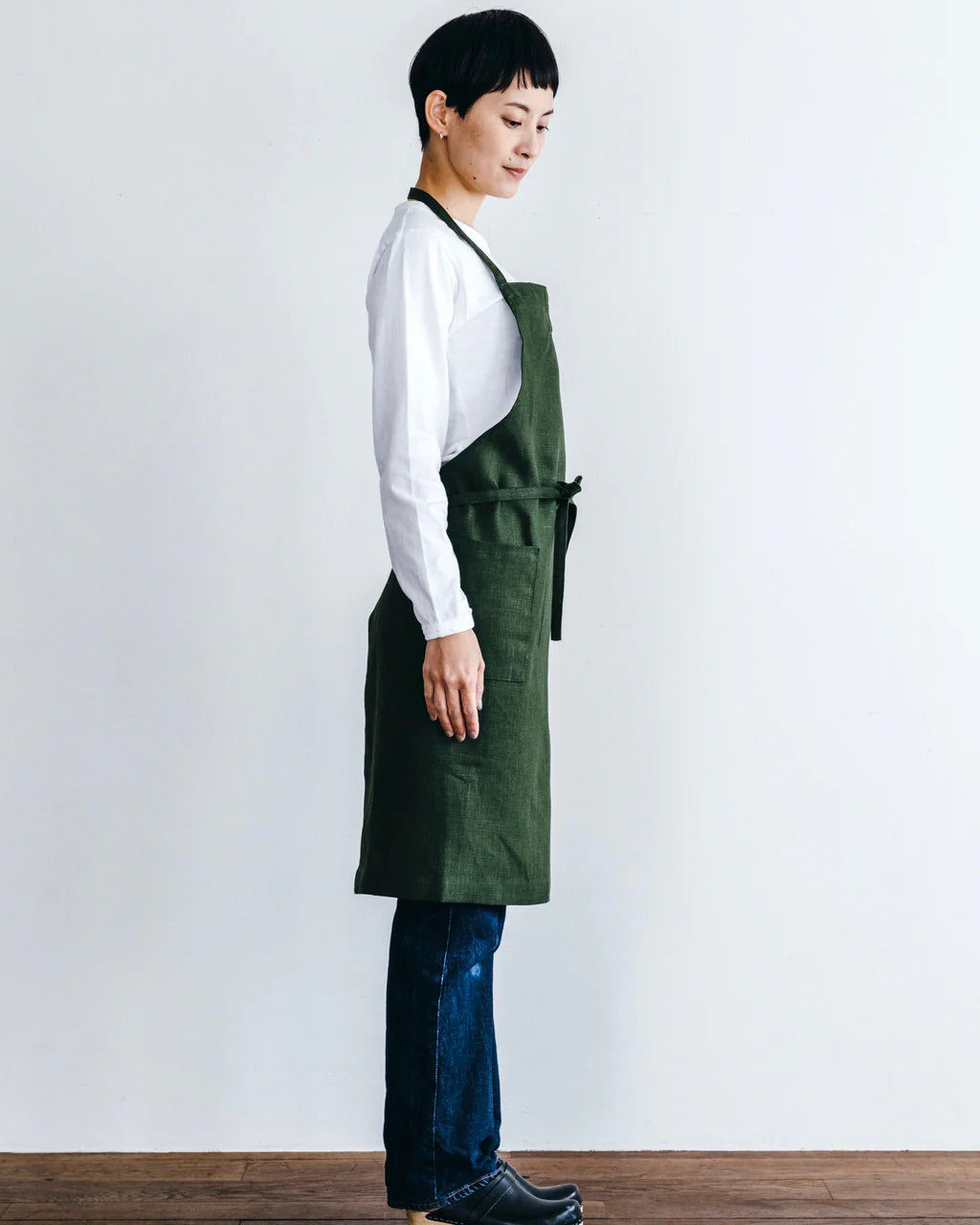Person wearing a green apron against a white background