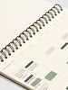 Spiral-bound planner with a minimalist design on a white background