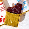 Chocolate bar with gold foil wrapper on a white surface with a floral patterned paper.