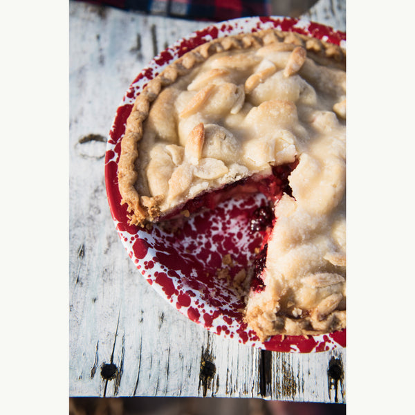 Partial view of a pie with a slice missing on a wooden surface