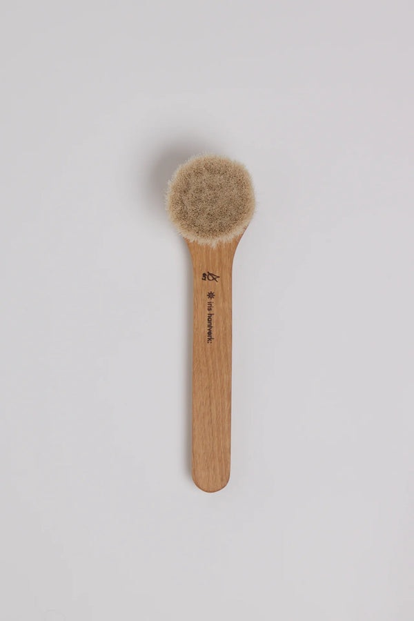 Wooden brush with bristle head on a light gray background