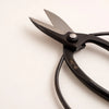 Black scissors with gold text on a white background