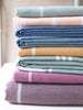 Stack of folded towels in various colors on a neutral background