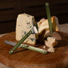 Cheese cutting set with a knife and cheese on a wooden board