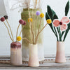 Set of ceramic vases with floral and decorative elements on a wooden surface.