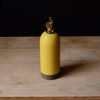 yellow ceramic oil bottle with gold cap on a wooden surface