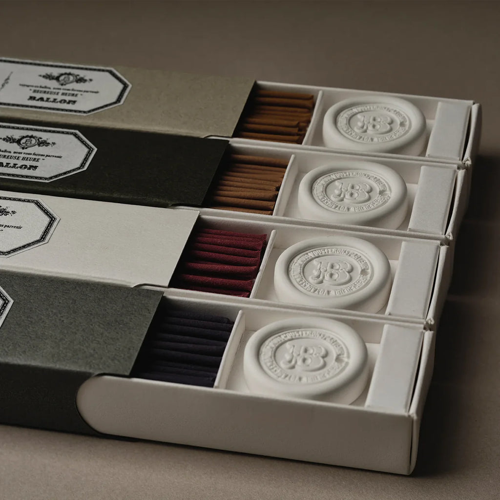 incense boxes with different colored incense and decorative labels on a brown background