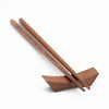 Wooden chopstick rest with two wooden chopsticks on a white background