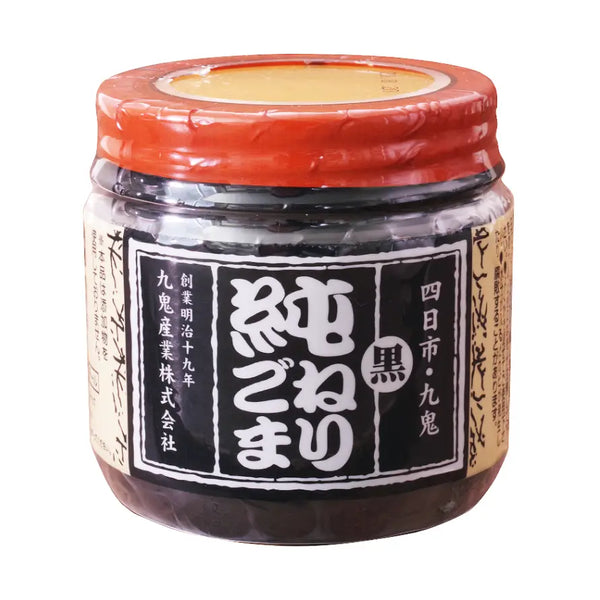 Jar of black sesame paste with a red lid on a white background