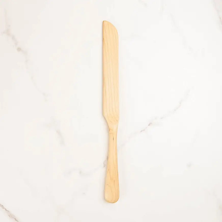 Wooden knife on a white marble surface