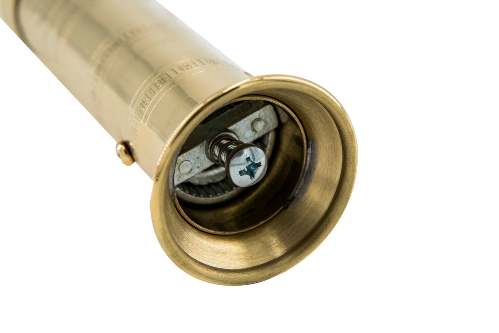Brass pepper mill with internal components on a white background