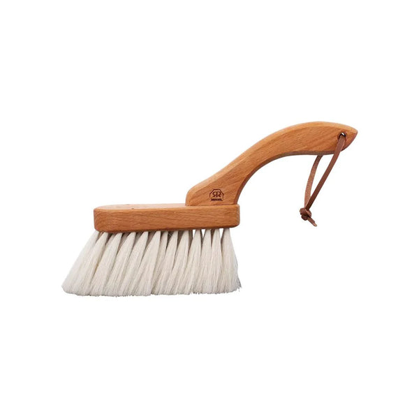 Cleaning brush with wooden handle and white bristles on a white background