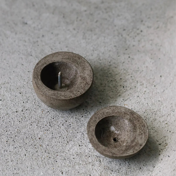Two small stone-like objects on a textured surface