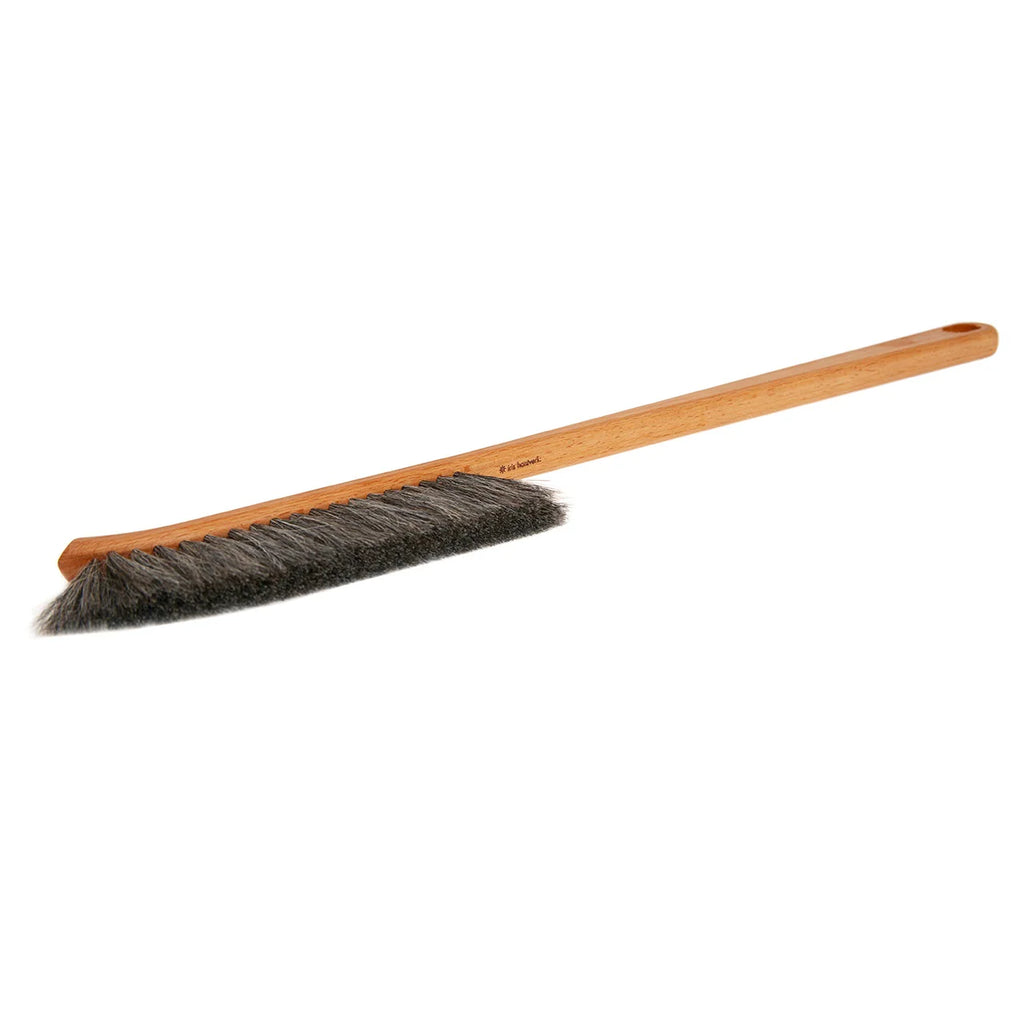 Brush with wooden handle and black bristles on a white background