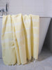 Yellow towel draped over a bathtub in a bathroom setting