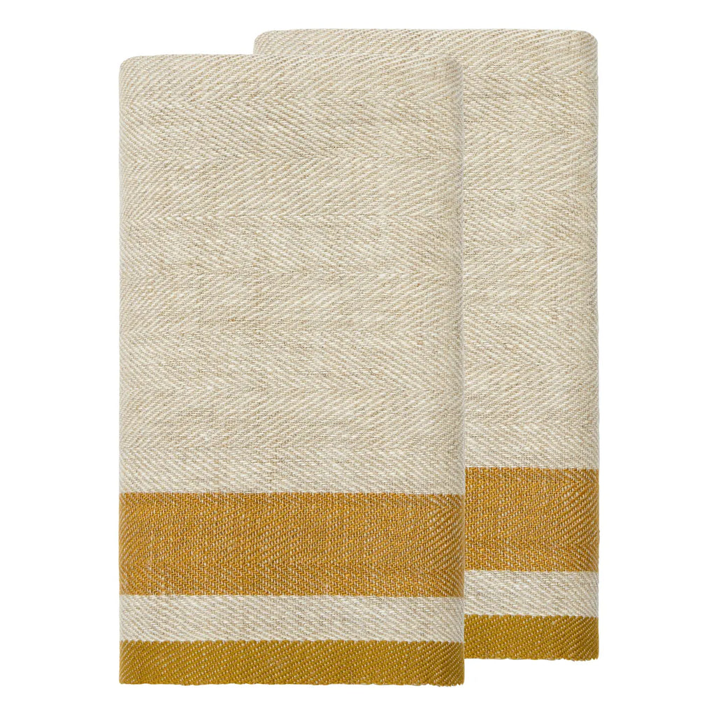 Two folded woven towels in a cream and mustard yellow herringbone pattern, stacked on a plain white background.