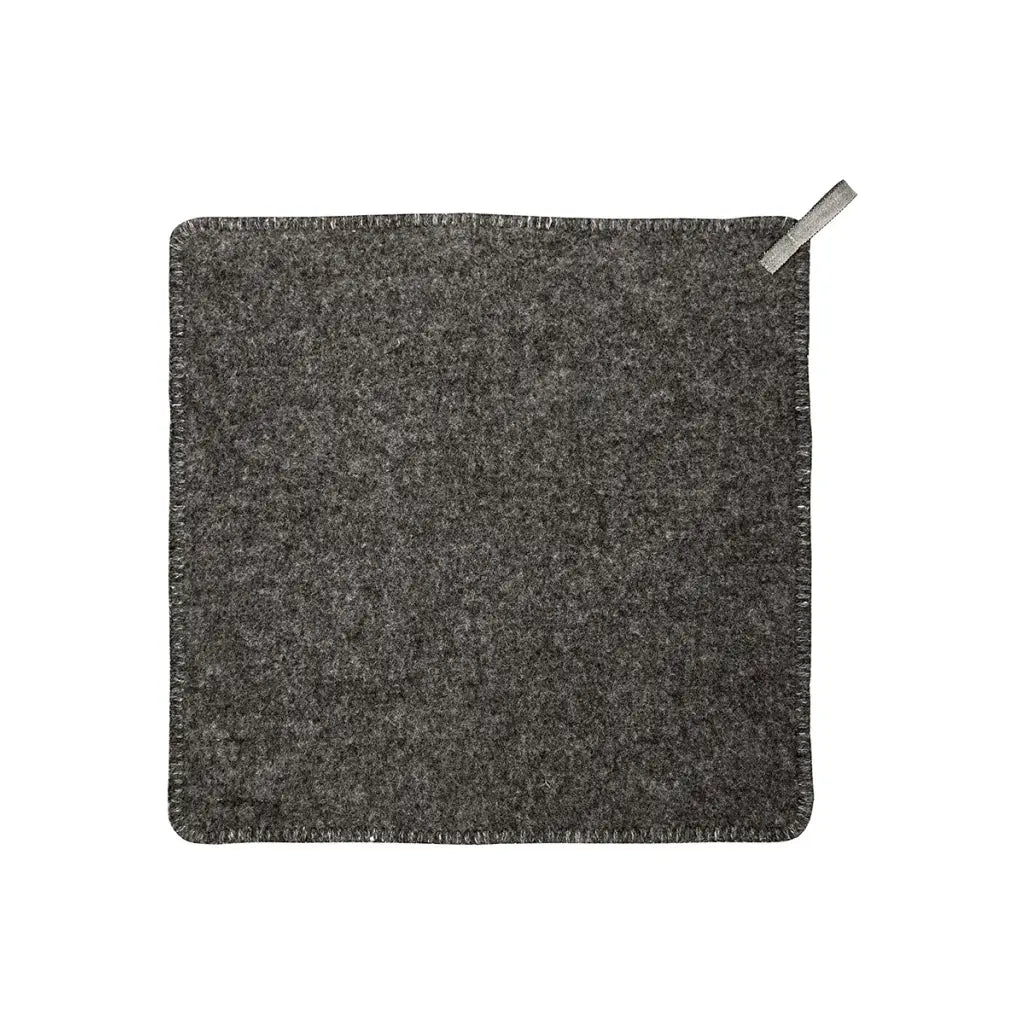 A square dark gray seat pad with a fringed edge and a small silver metal pull tab in the top right corner, shown on a plain white background.