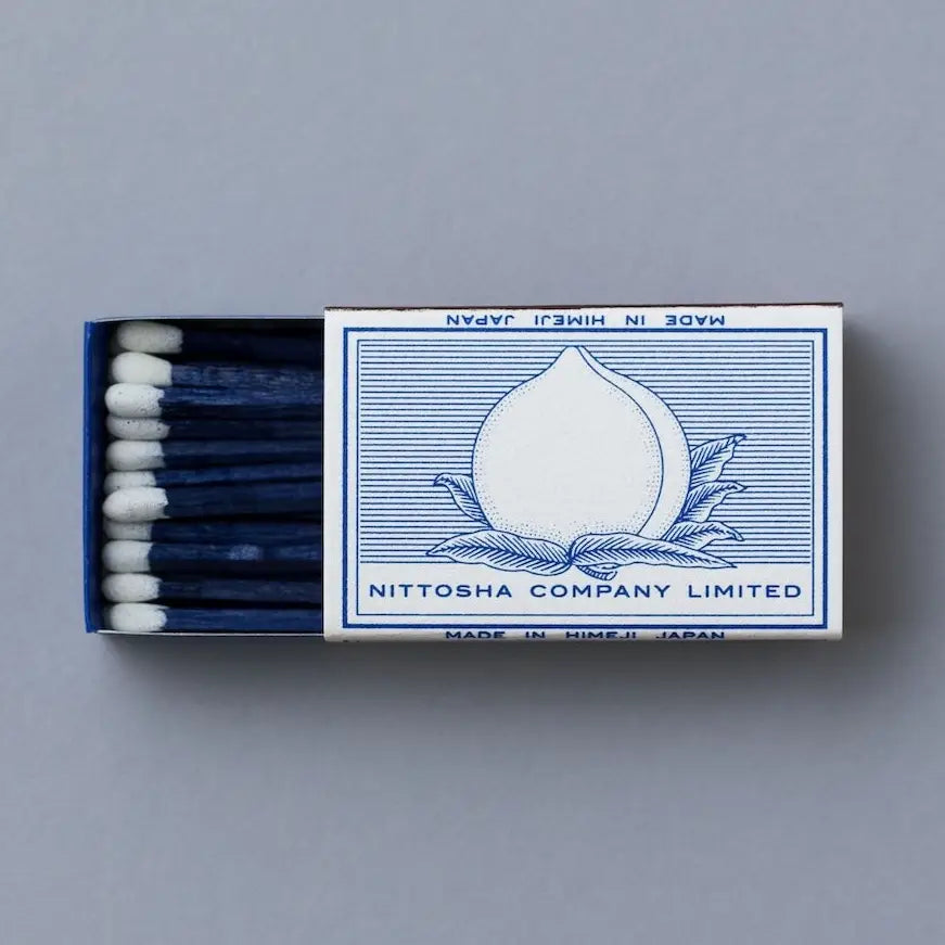 Indigo match box with a peach on the front.