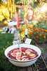 Outdoor setting with a bowl of fruit punch and people in the background
