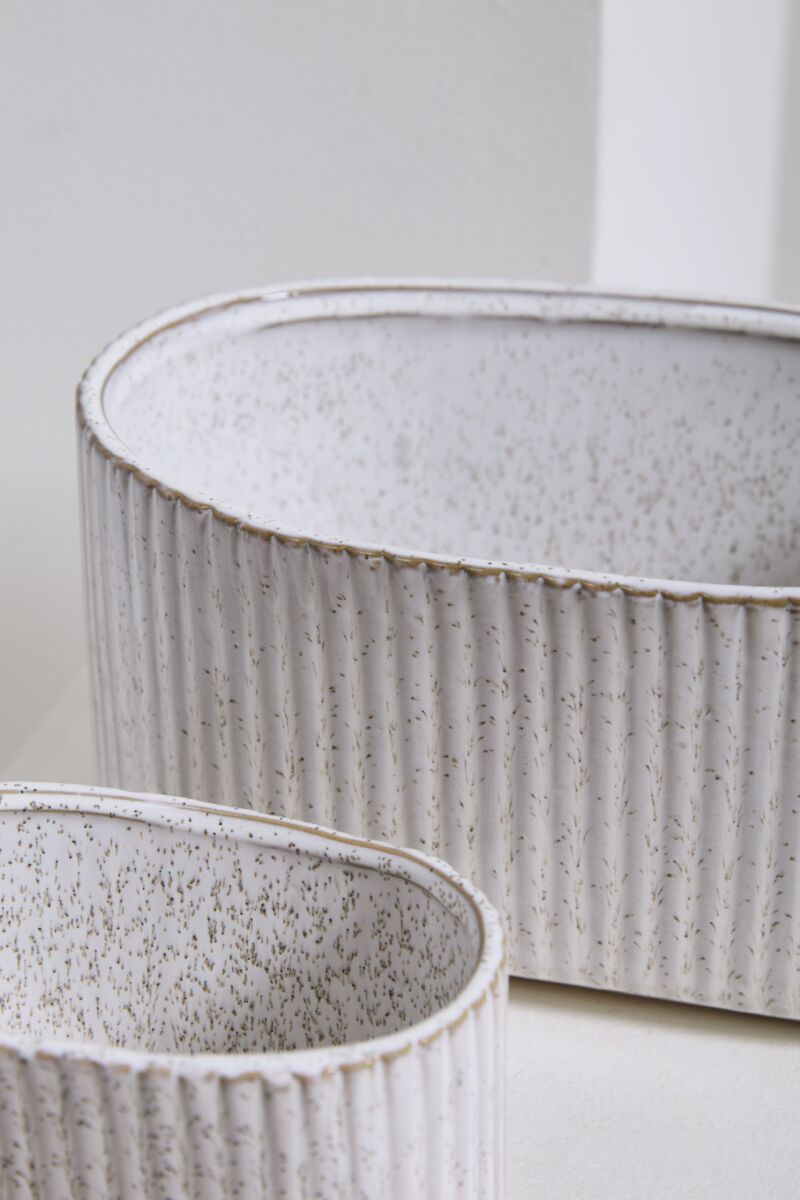 Two textured ceramic planters on a light background