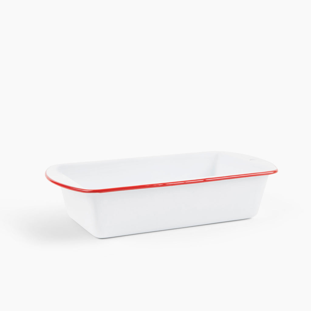 Rectangular white baking dish with red rim on a white background